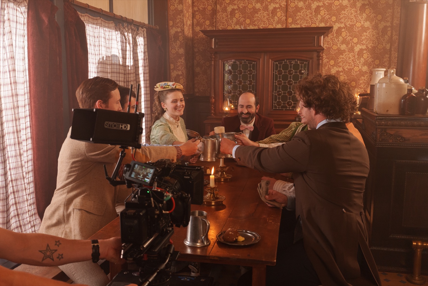 Shooting a scene in a period parlor, camera crew mid-take.